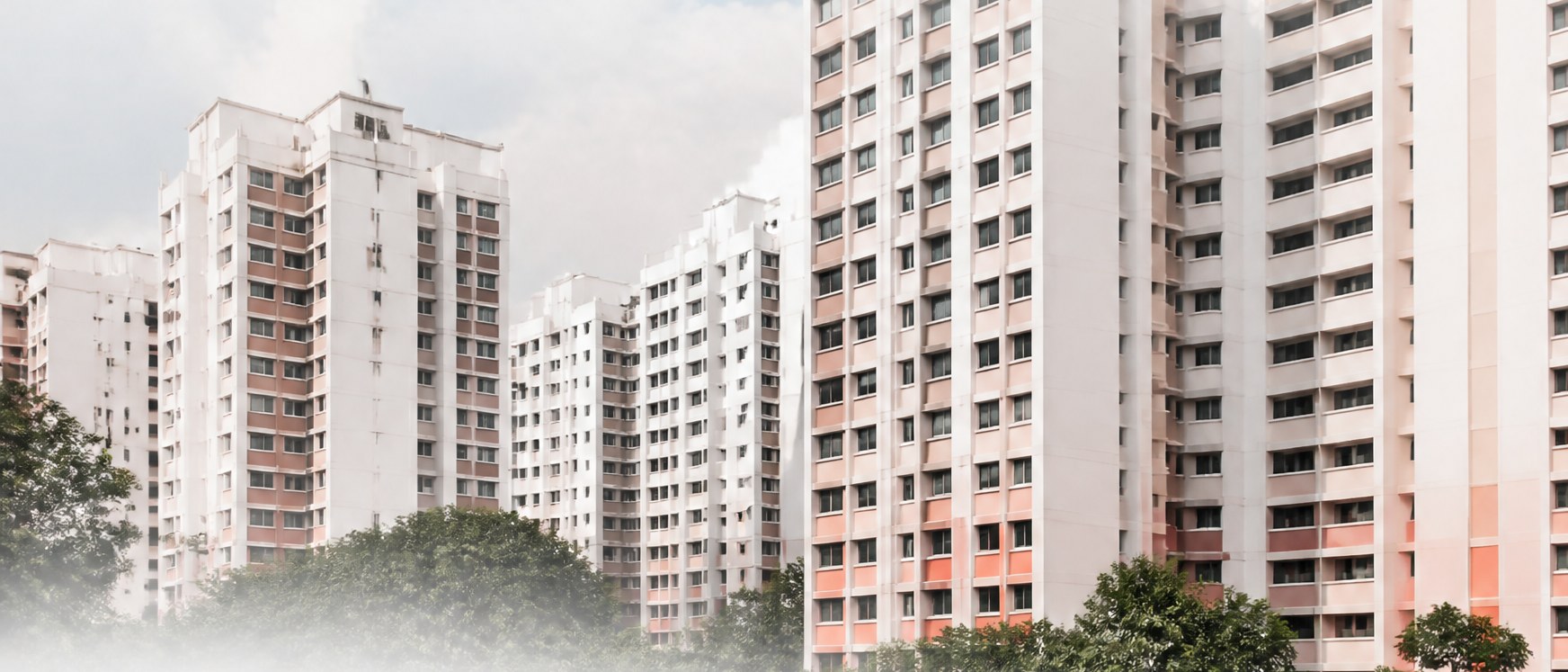 Row of HDB residential blocks against a cloudy sky
